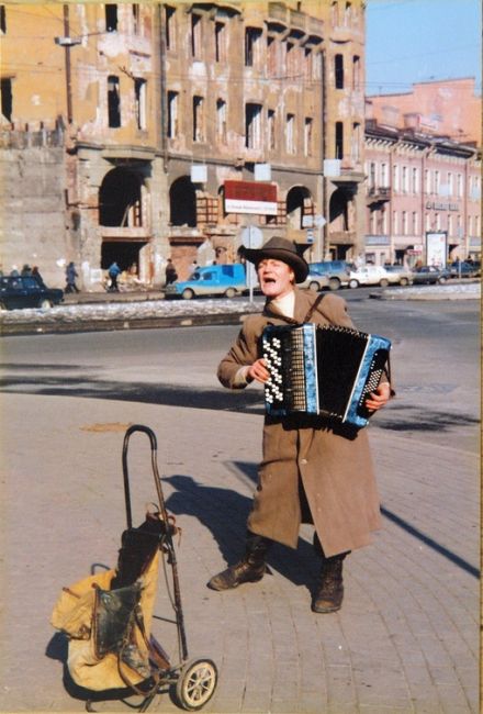 Уличный музыкант, напоминающий комика Александра Гудкова, выступает посреди разрухи на Владимирской..