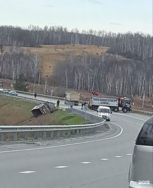 На трассе возле Мошково фура пробила ограждение и почти ушла в кювет, рассыпав груз. Кадры с места ДТП..